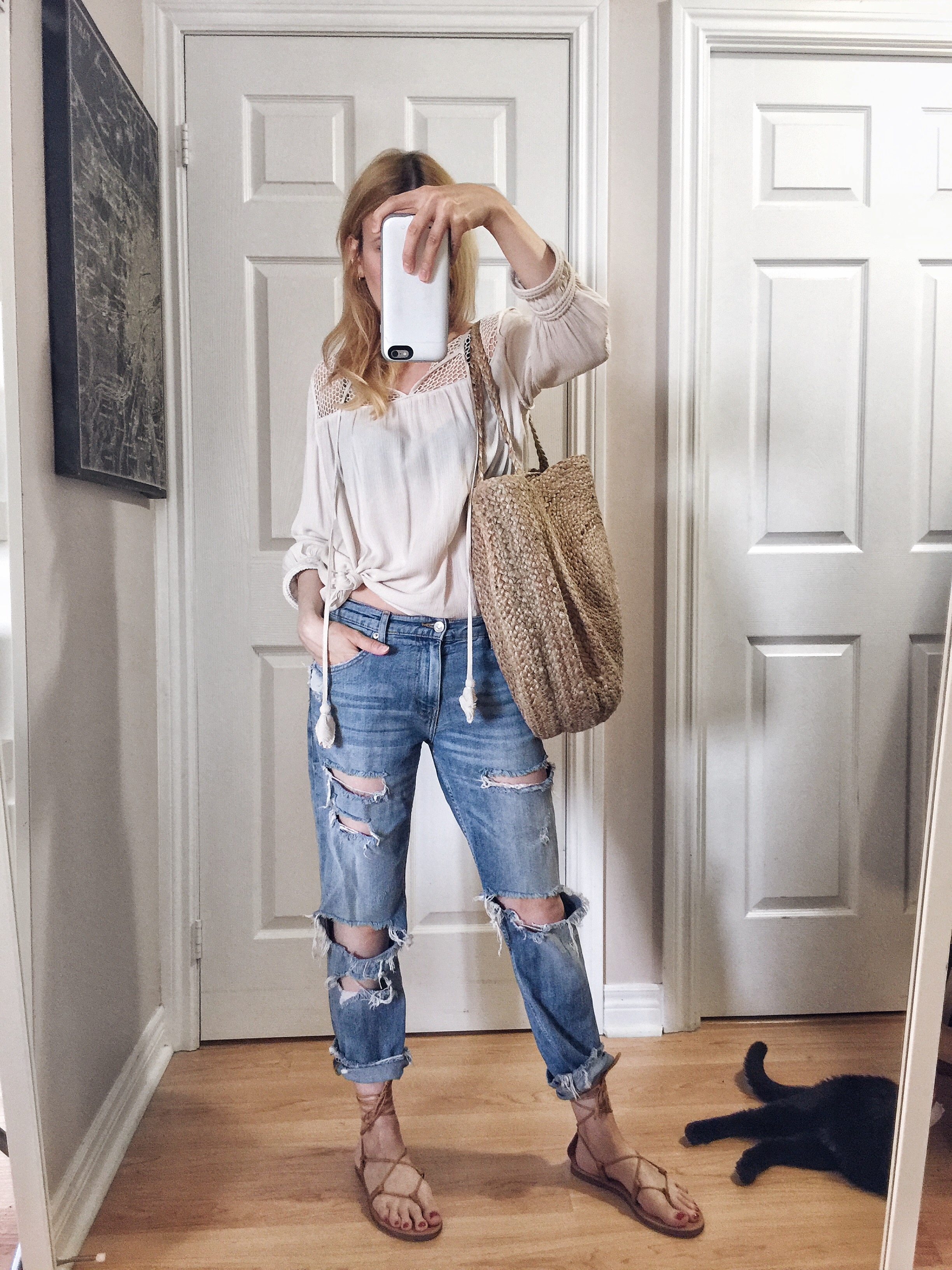 I am wearing a peasant top, boyfriend jeans, Madewell Boardwalk sandals, and a large woven circle purse