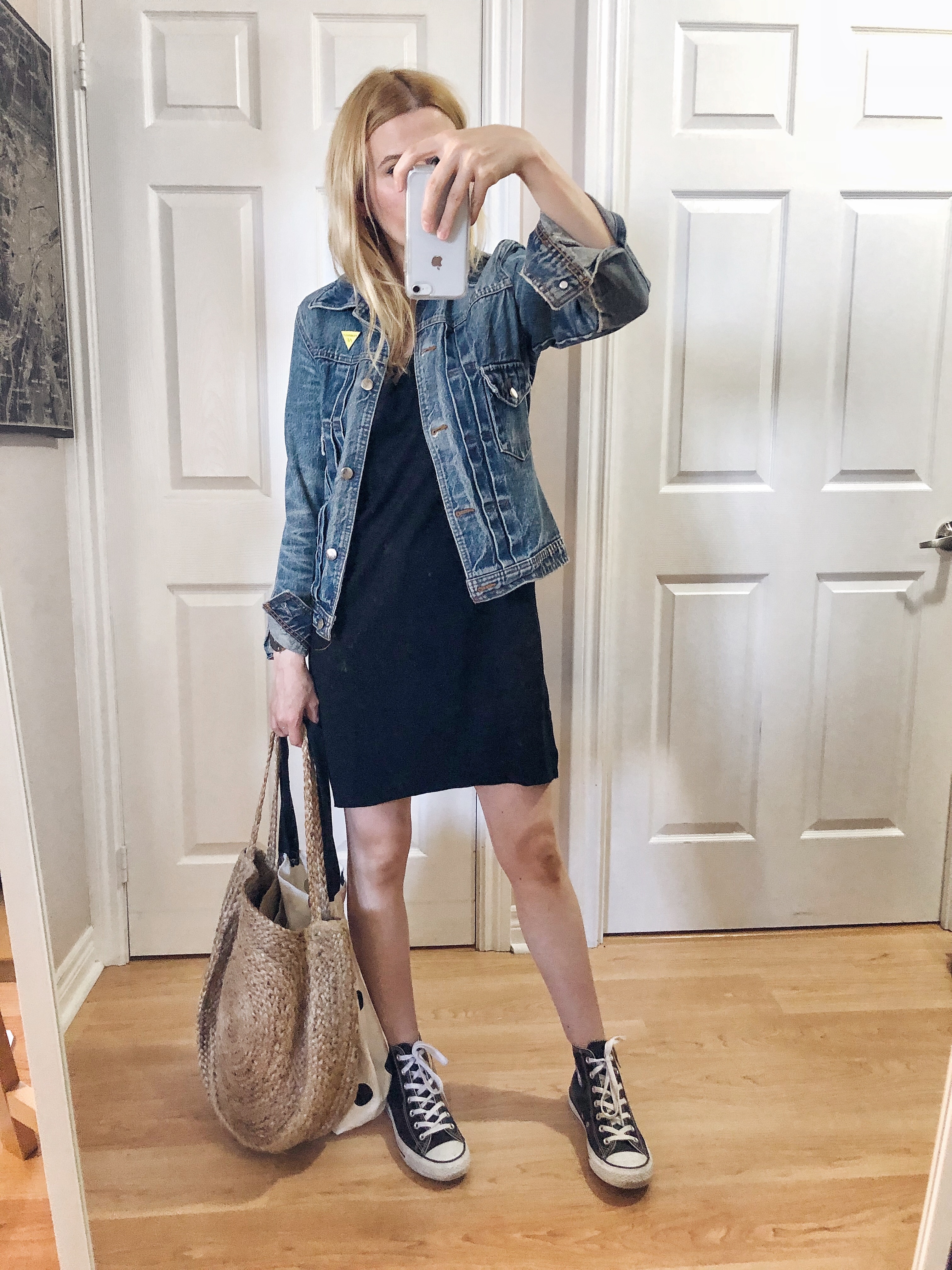 I am wearing a t-shirt dress, jean jacket, a large woven bag and converse high tops.