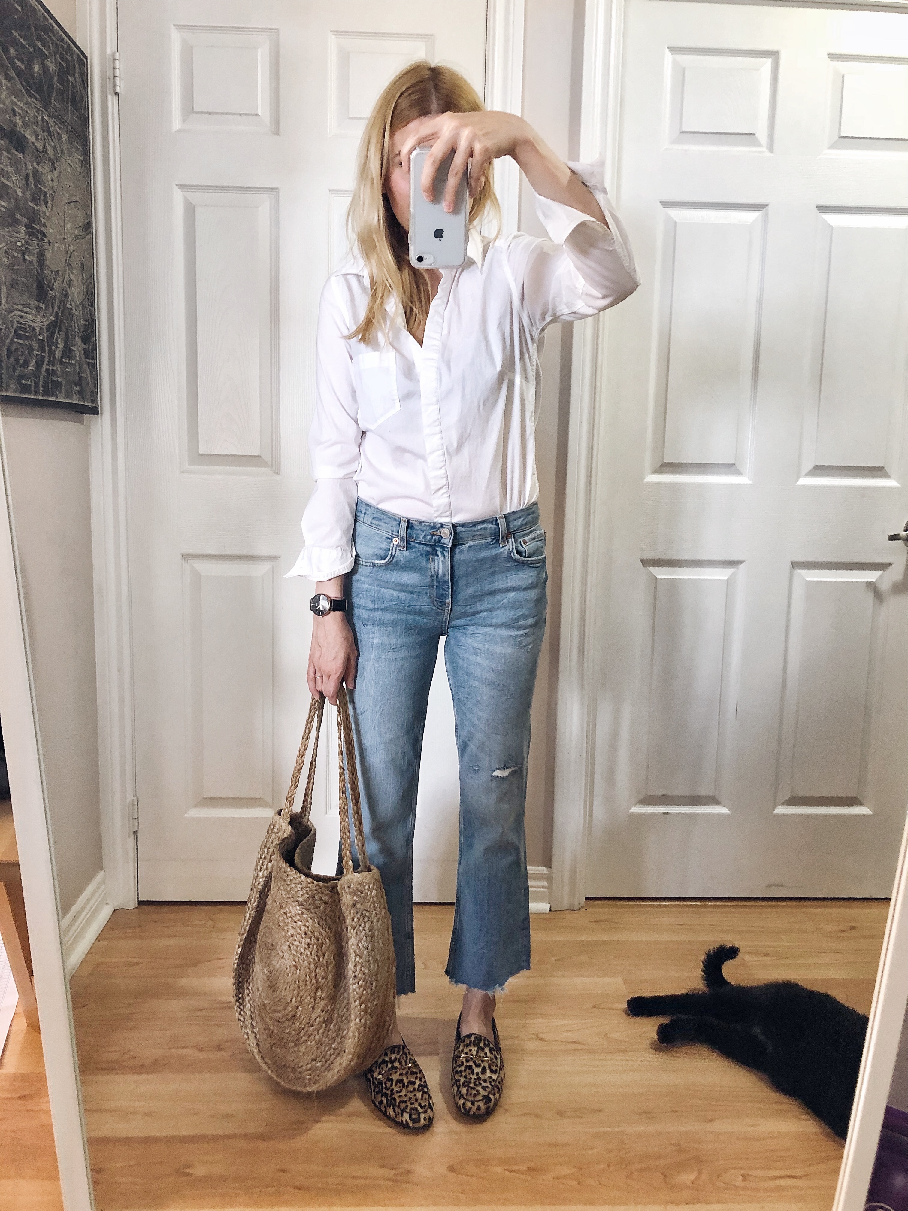 I am wearing a white blouse, cropped jeans, animal print loafers, and a large woven tote.