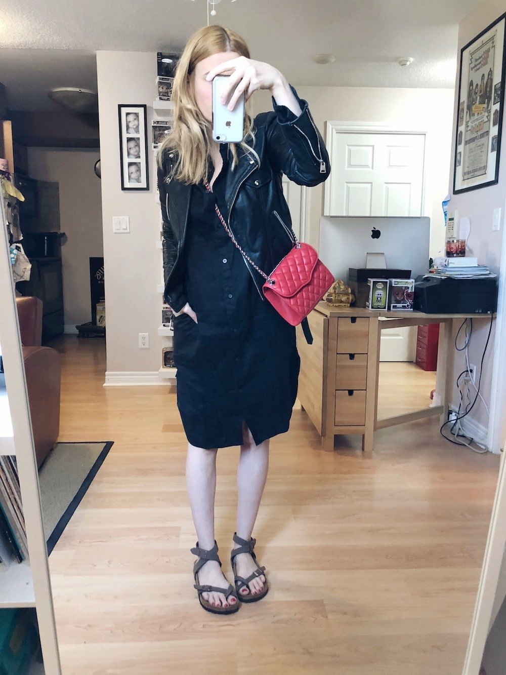 I am wearing an Everlane linen shirt dress, Birkenstock Yara sandals, a moto jacket, and a red Rebecca Minkoff purse. 