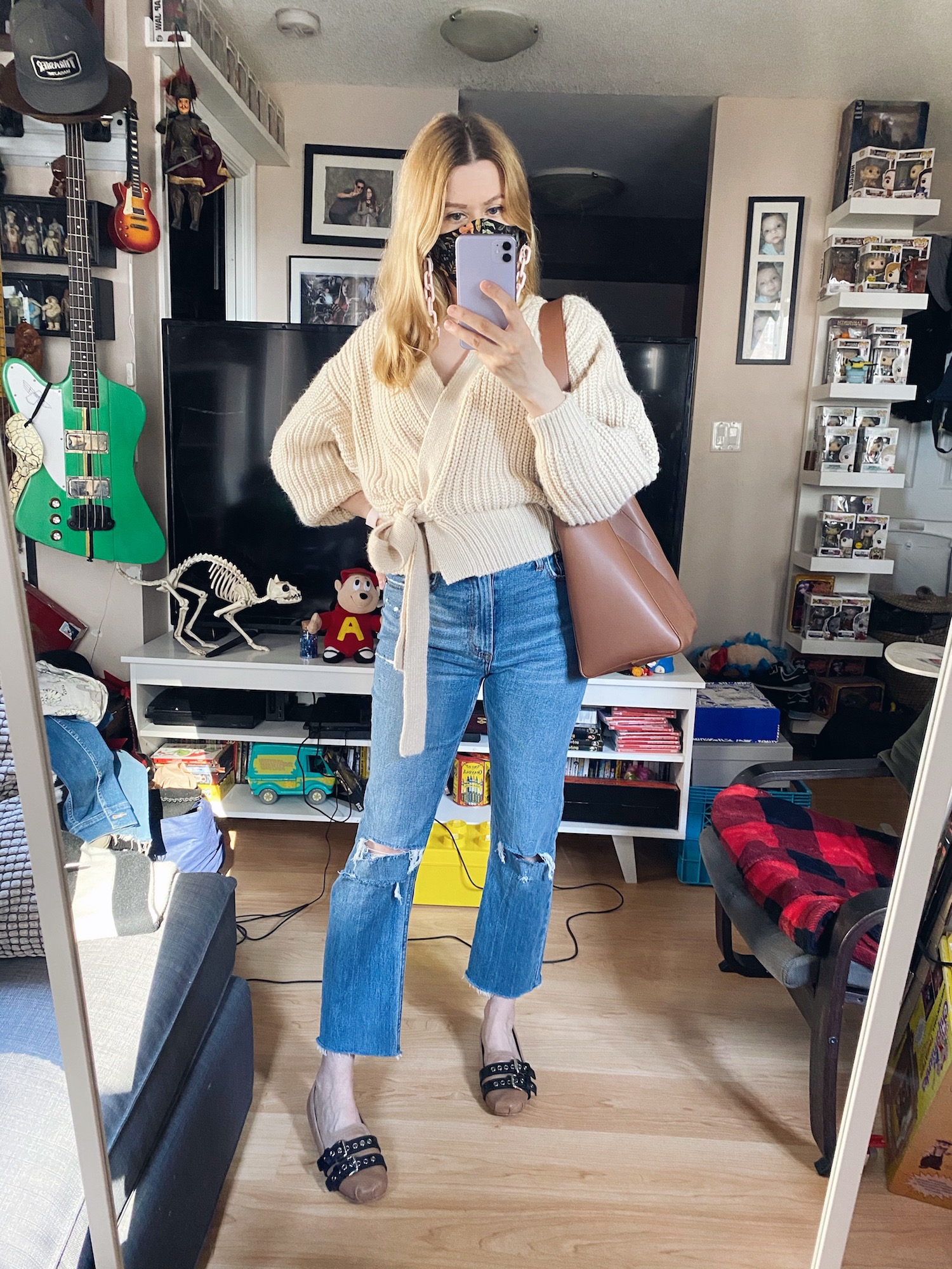 Blogger Sara Watson is wearing a cream wrap cardigan, Abercrombie jeans, Miu Miu Flats, a face mask, and a brown Everlane Tote