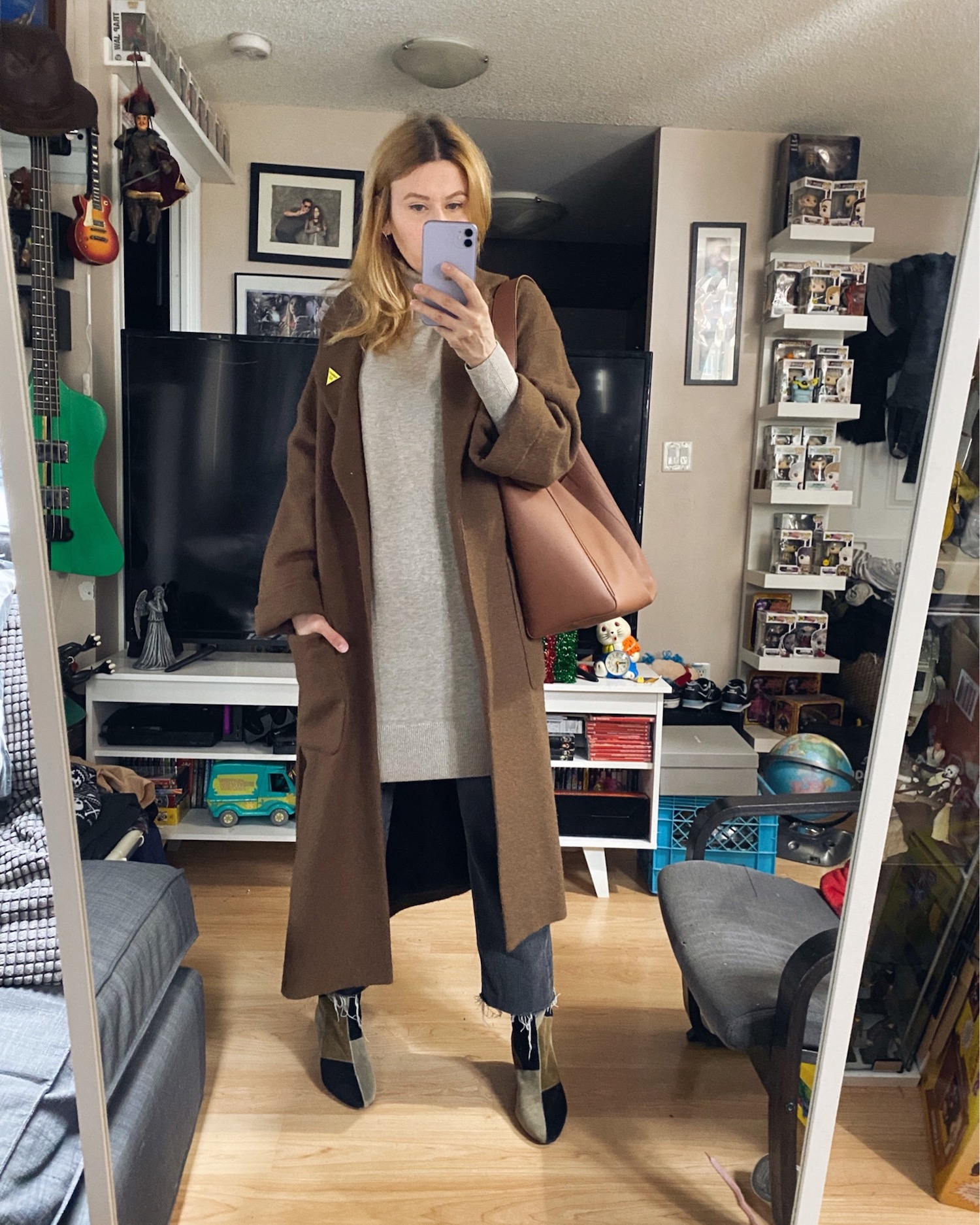 Blogger Sara Watson is Wearing an Oatmeal coloured sweater dress from Everlane, with black Levis, a brown wool coat, and Isabel Marant boots.