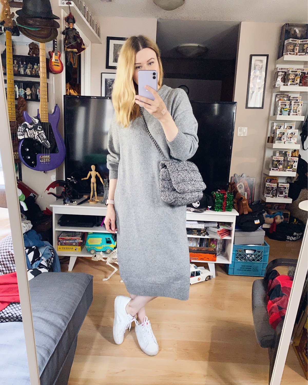 Blogger Sara Watson is wearing a grey sweater dress, white Golden Goose sneakers, and a Zara bag.