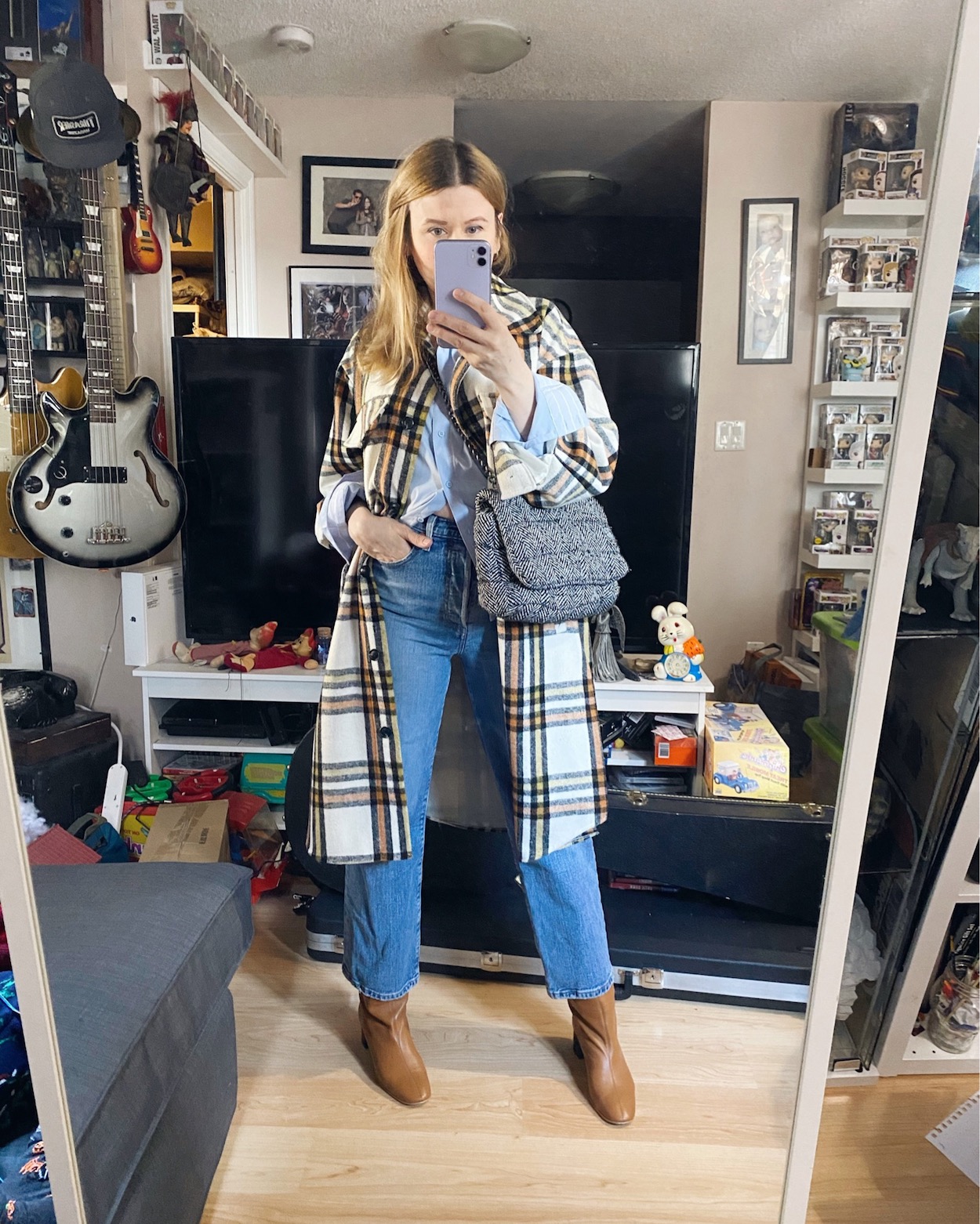 I am wearing a blue button up, Levis, a plaid dhacket, and knee high boots tucked under jeans