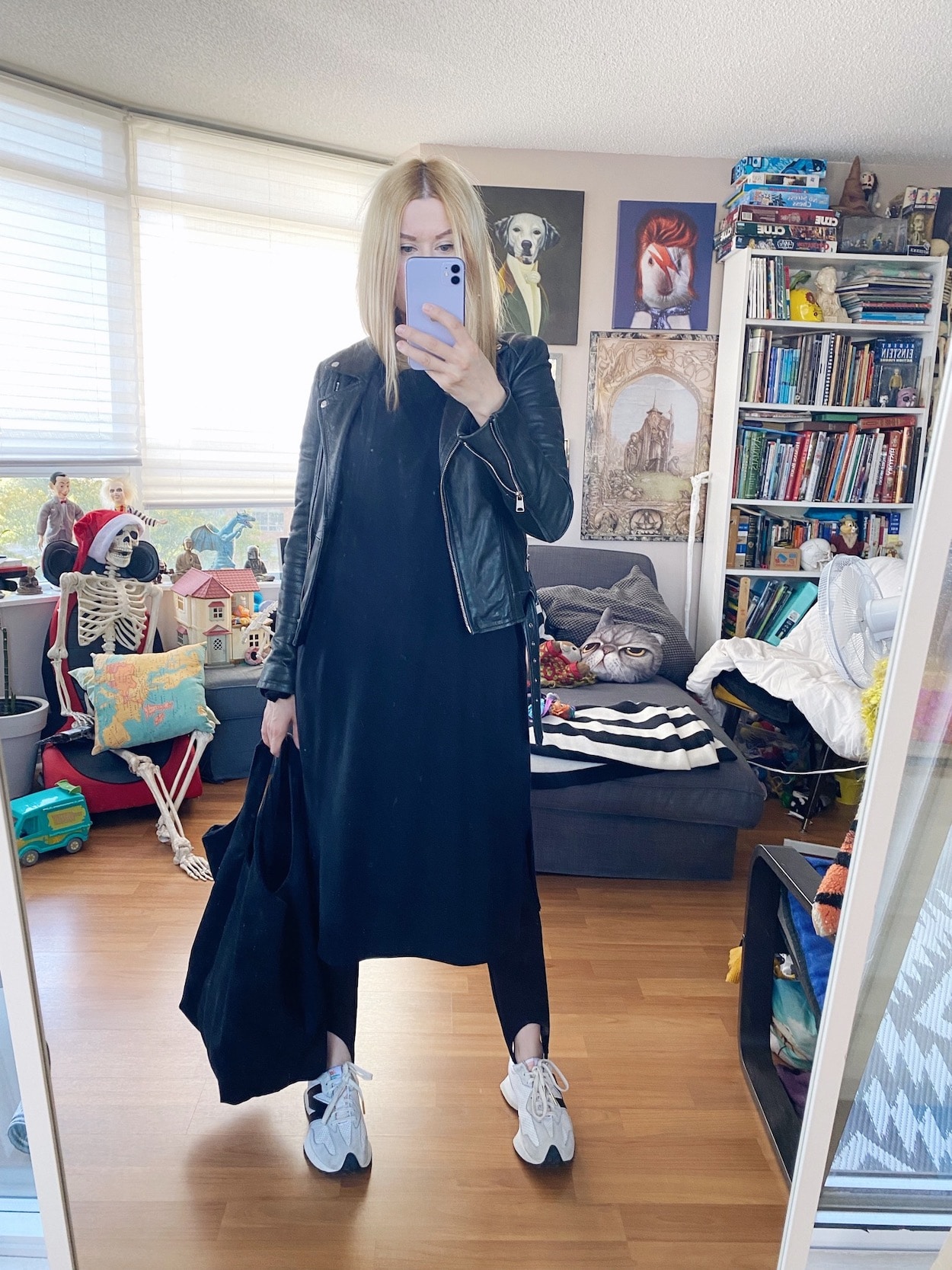 I am wearing a black midi dress, stirrups, a leather jacker, New Balance sneakers, and a black tote.