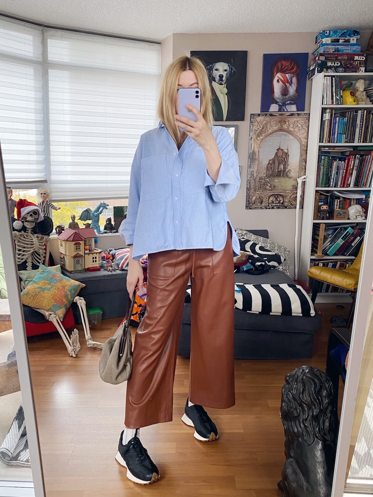 I am wearing a blue button up, brown wide leg faux leather pants, Black New Balance 327s, and a vintage Miu Miu bag.