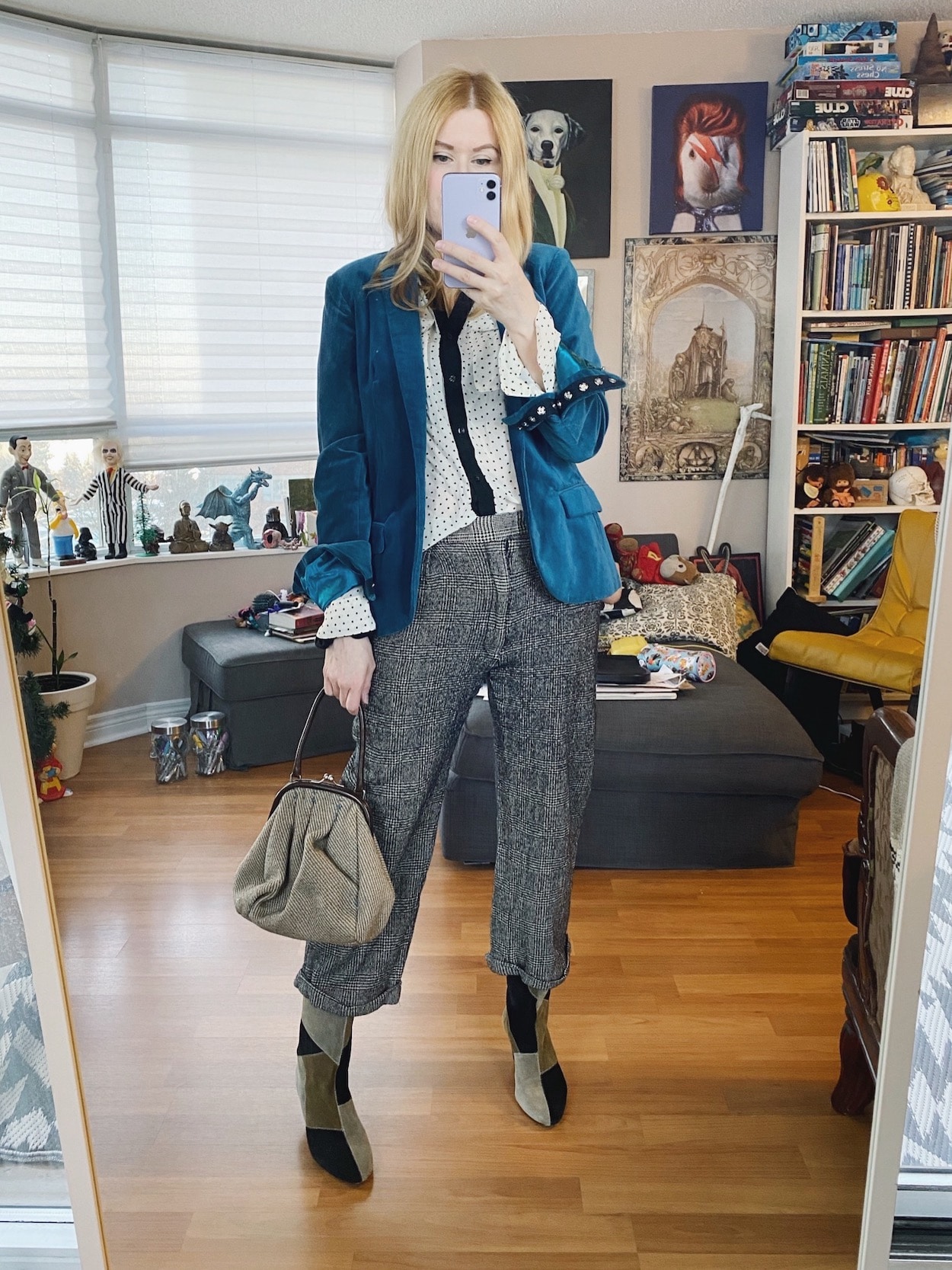 A blonde woman is wearing vintage men's trousers, a polka dot blouse, a blue velvet blazer, Isabel Marant patch boots, and a vintage Miu Miu bag.