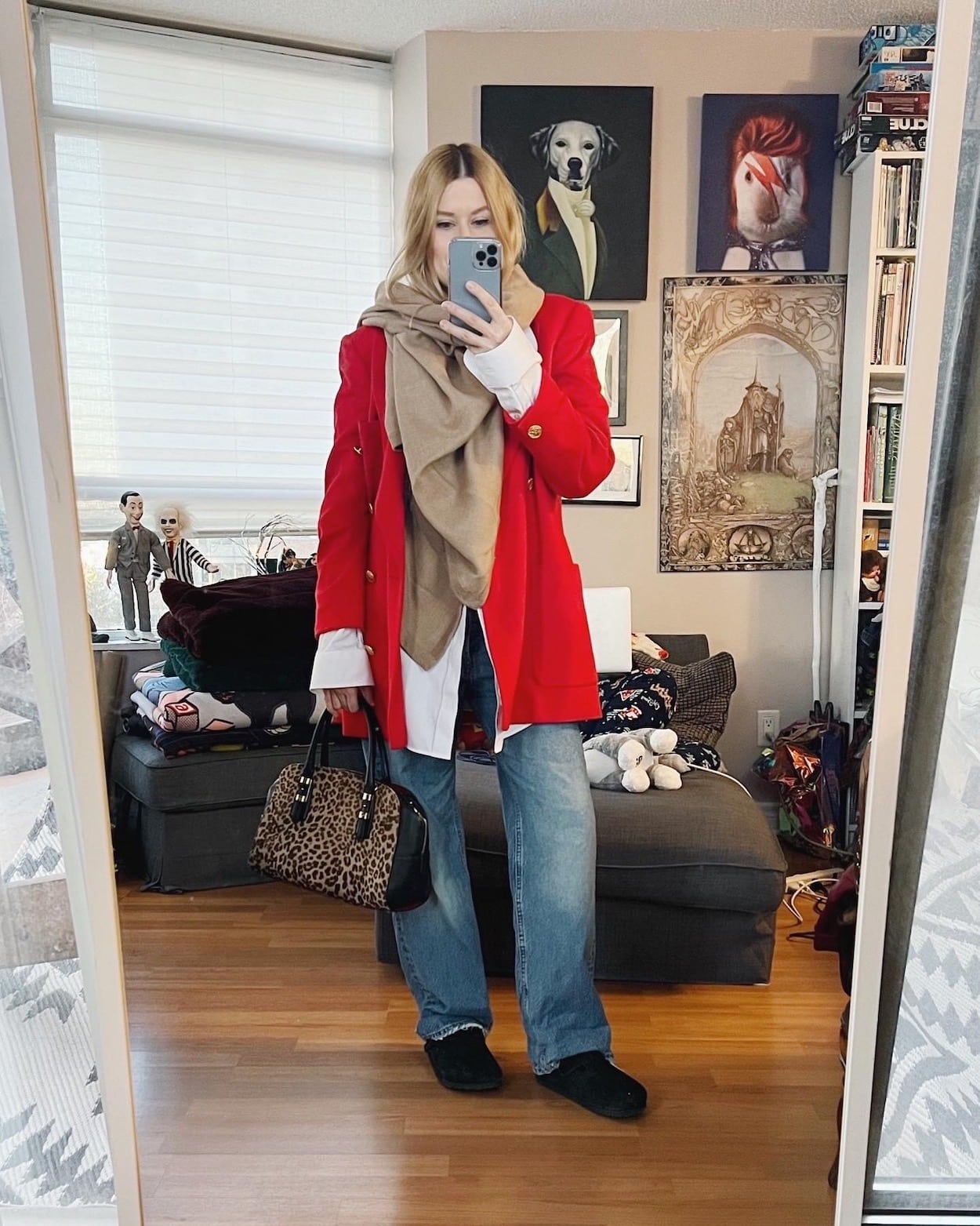 A blonde woman is wearing a white button up, boyfriend jeans, Birkenstock bostons, a red vintage blazer, a camel scarf, and is carrying an animal print bag.