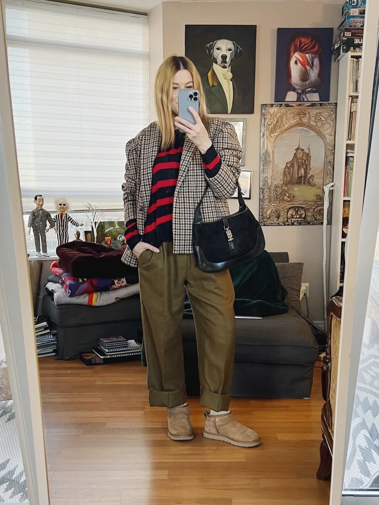 A blonde woman is wearing a srtiped sweater, oversized blazer, men's vintage trousers, Ugg minis, and a vintage Gucci bag.