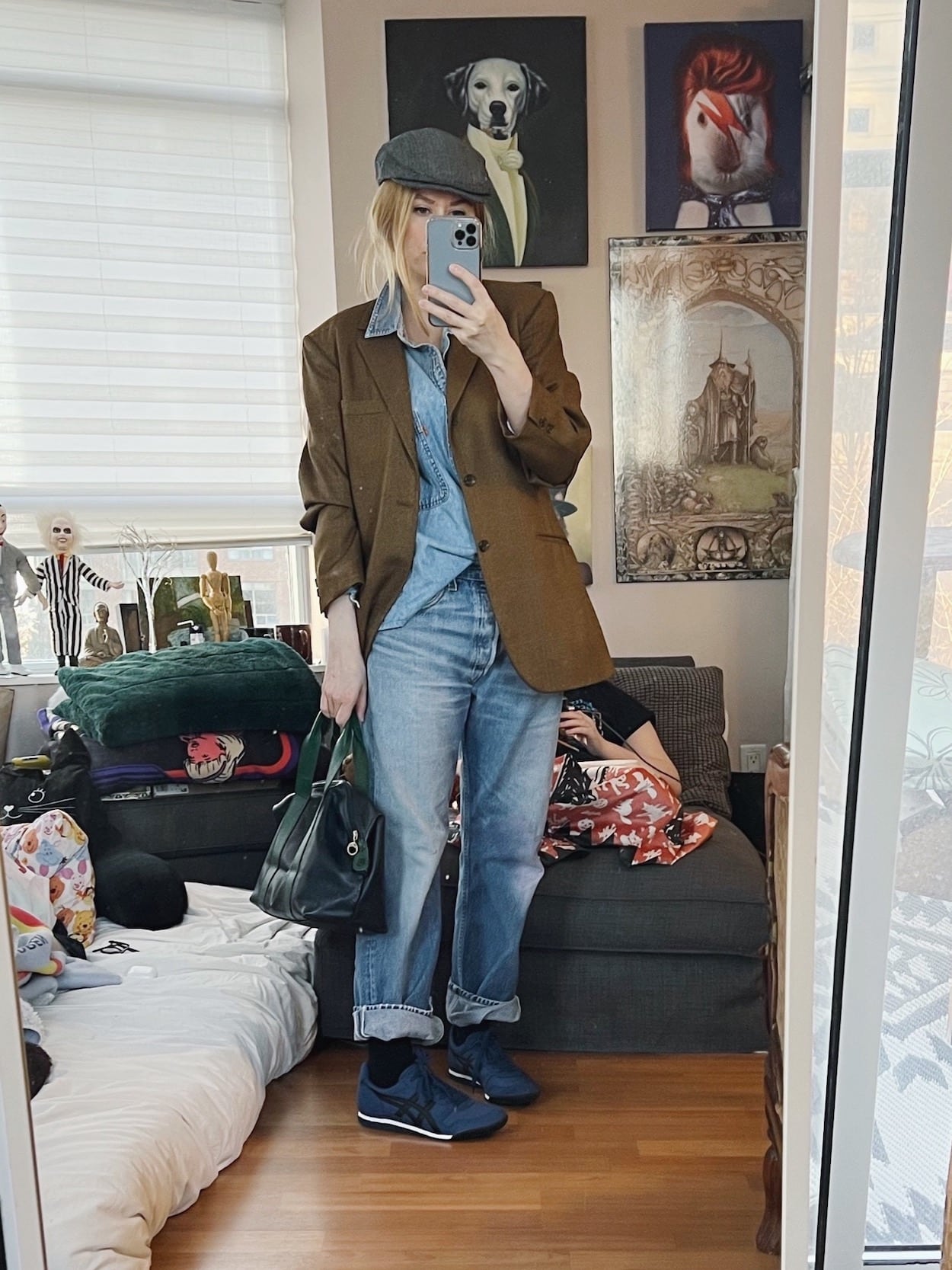 A blonde woman is wearing vintgae Levi's, a denim shirt, vintage blazer, driving cap, vintage bag, and Onitsuka Tiger sneakers.