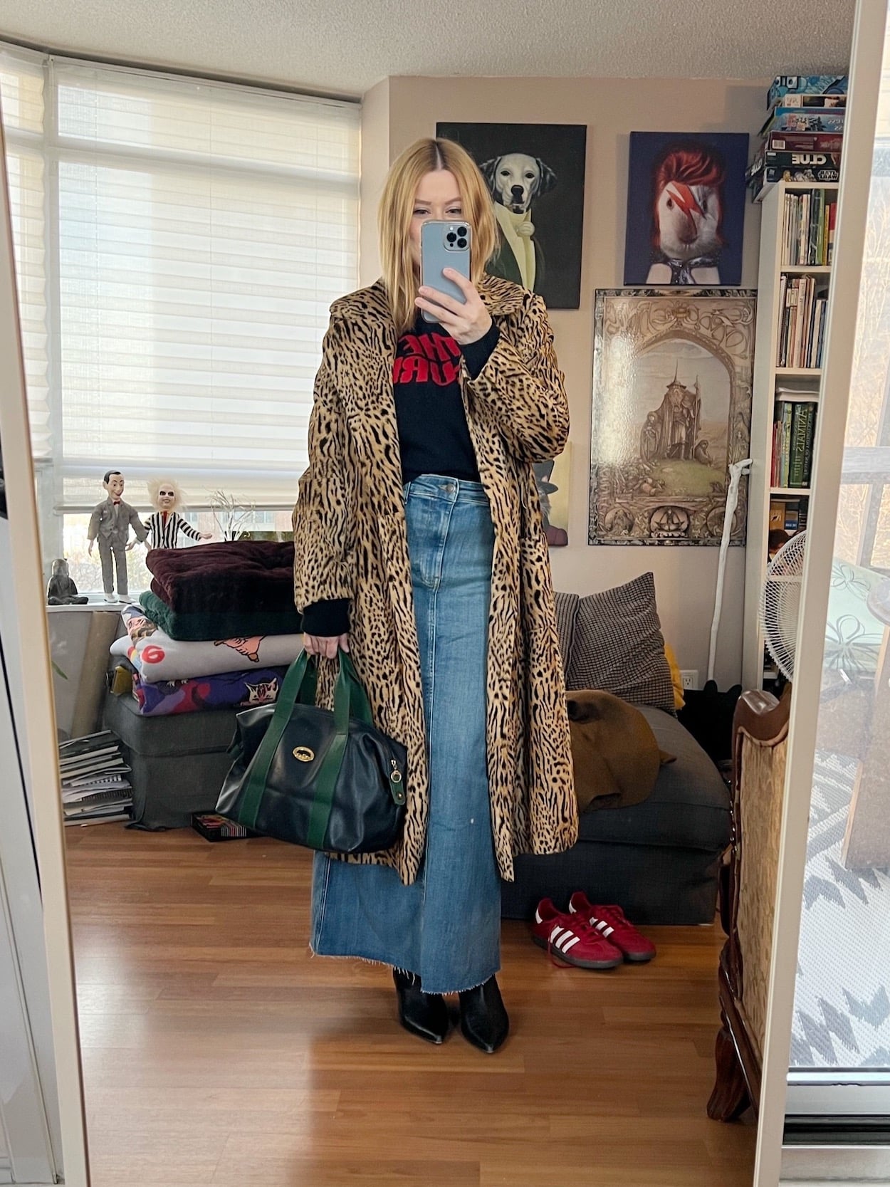 A blonde woman is wearing a Cure sweater, with a denim maxi skirt, a vintage jacket, a vintage Longchamp bag, and kitten heel boots.