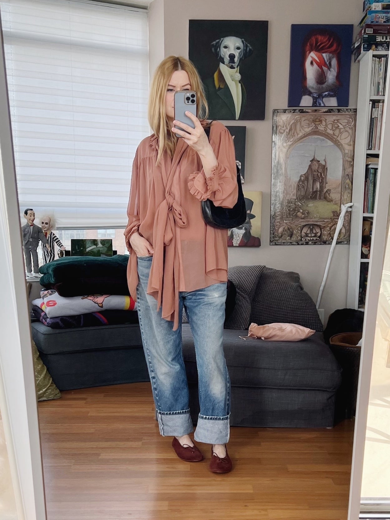 Sara of livelovesara is standing in front of a mirror taking a photo of her outfit. She is wearing a pink vintage flowy blouse, vintage jeans, brown ballet flats, and a vintage Gucci Jackie bag.