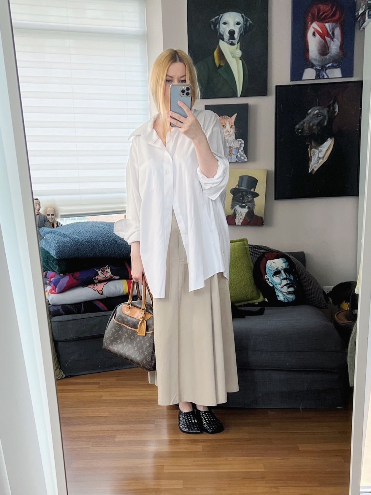 Sara of livelovesara is standing in front of a mirror taking a photo of her outfit. She is wearing a men's white button up, maxi cargo skirt, woven flats, and a vintage Louis Vuitton bag.