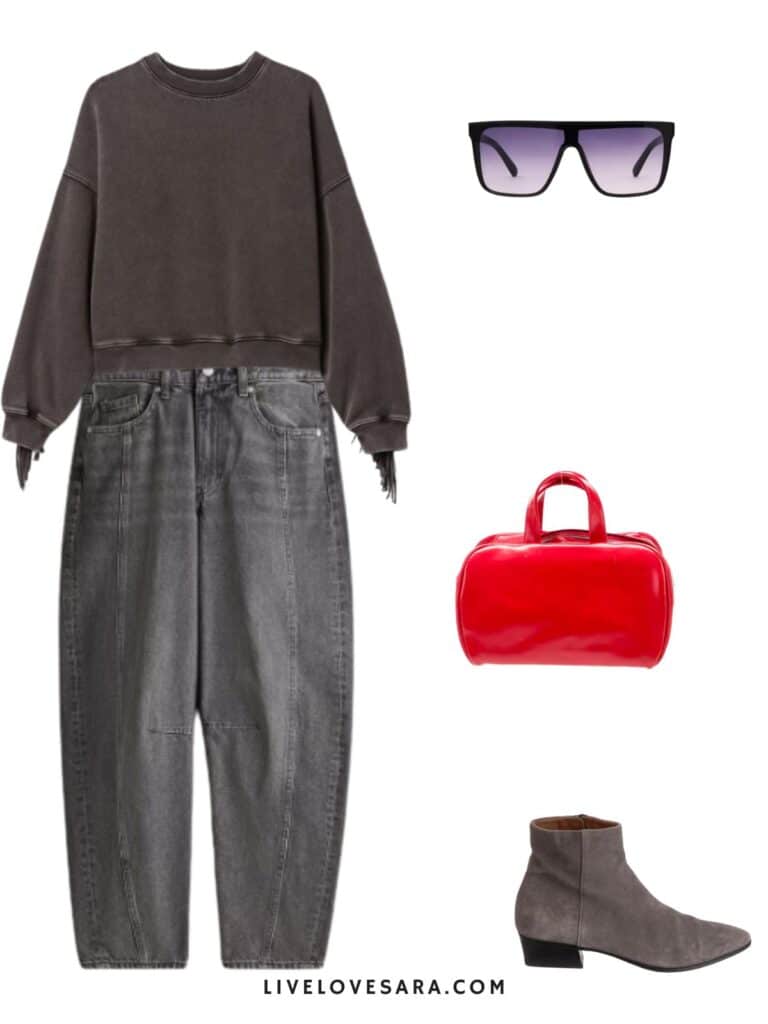 a photo of an outfit of a fringe sweatshirt, grey jeans, grey boots, a red hangbag, and sunglasses.