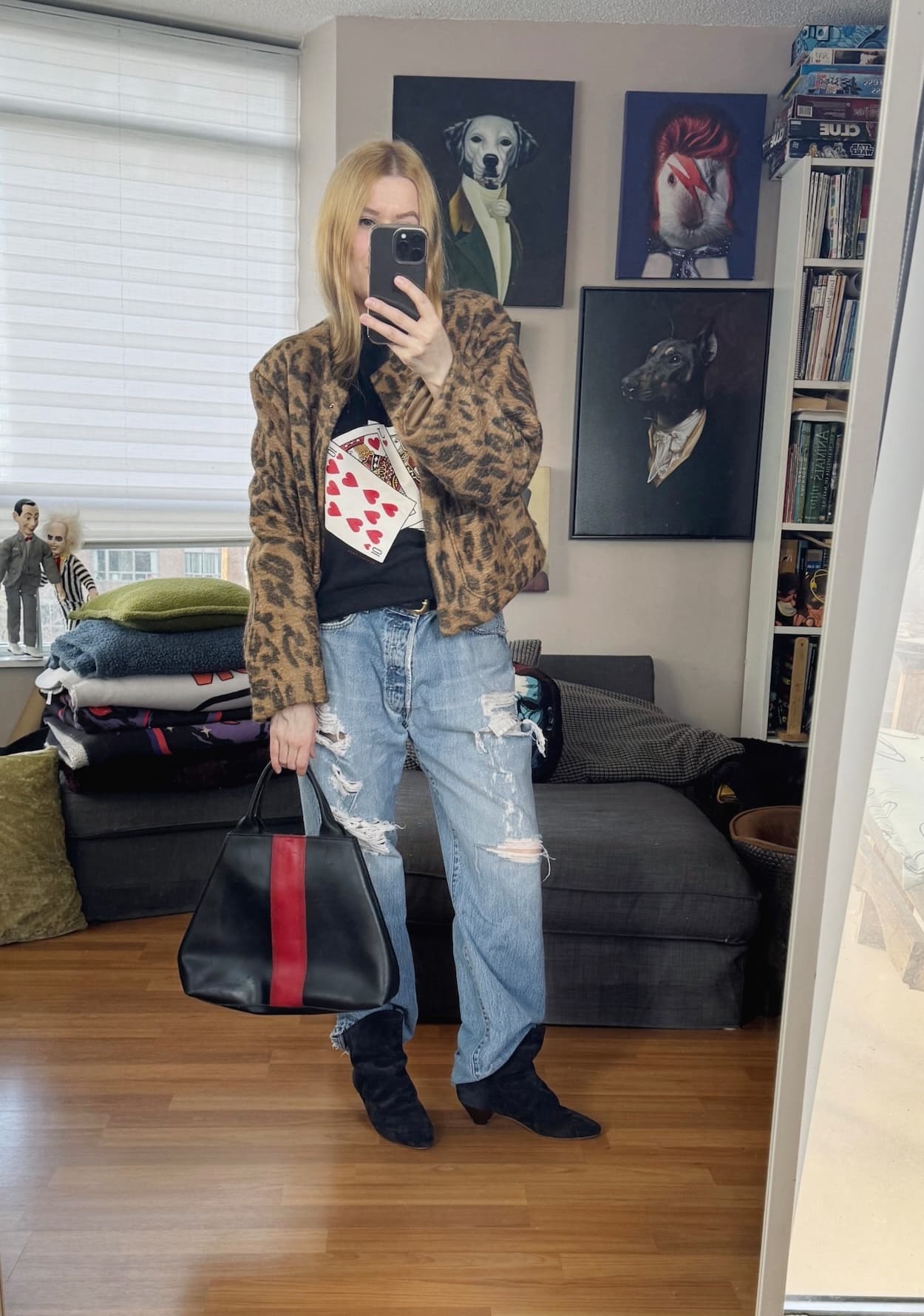 Sara of livelovesara is standing in front of a mirror taking a photo of her outfit. She is wearing a vintage sweatshirt under an animal print coat, vintage levis, Isabel Marant Boots, and a Furla bag.