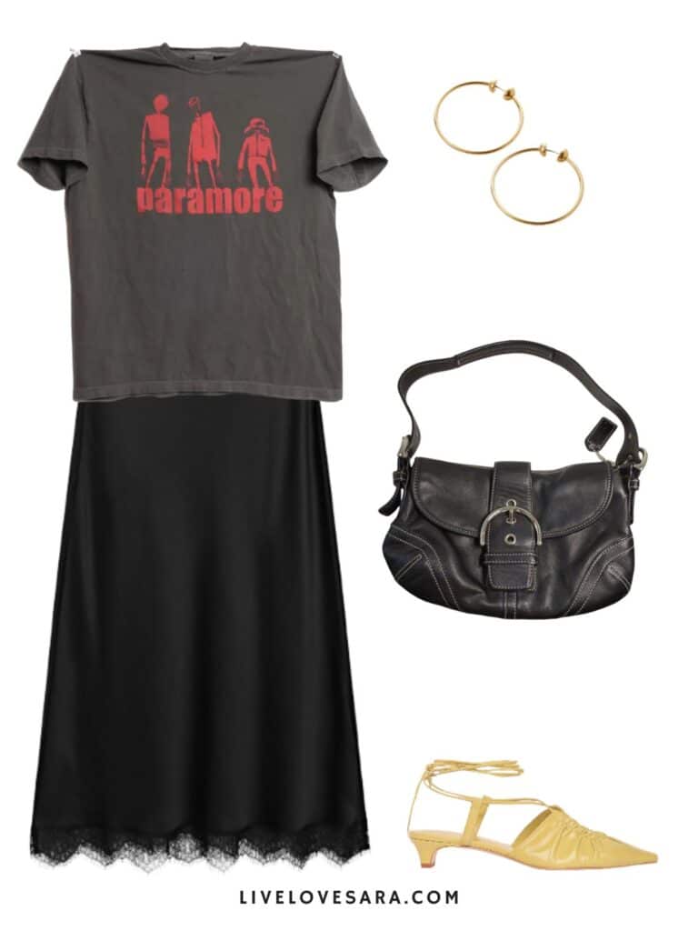 A photo of an outfit of a paramore tee, satin skirt, yellow kitten heels, a black bag, and earrings.