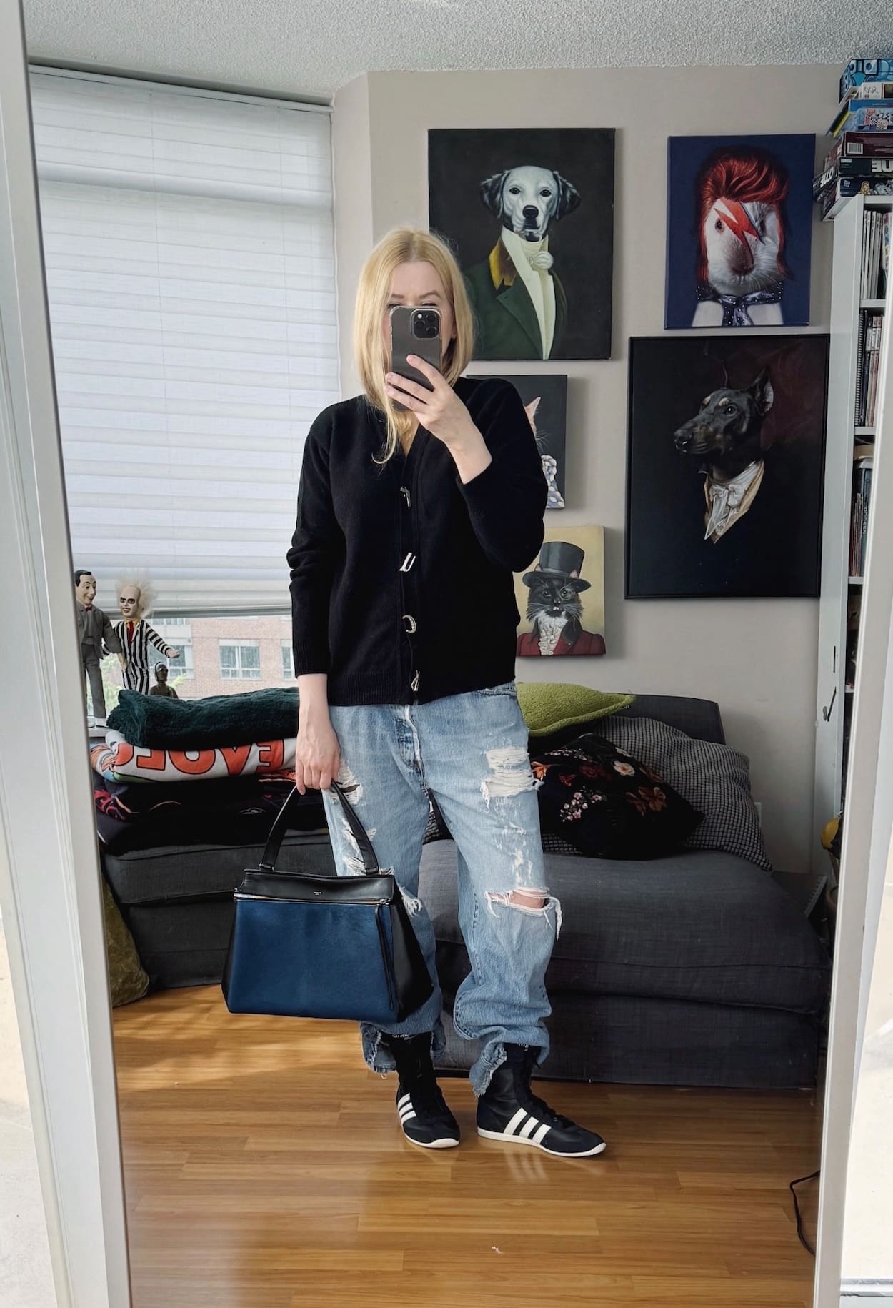 Sara of livelovesara is standing in front of a mirror taking a photo of her outfit. She is wearing a fuck buttons cardigan, vintage Levis, Adidas wrestling boots, and an old celine bag.