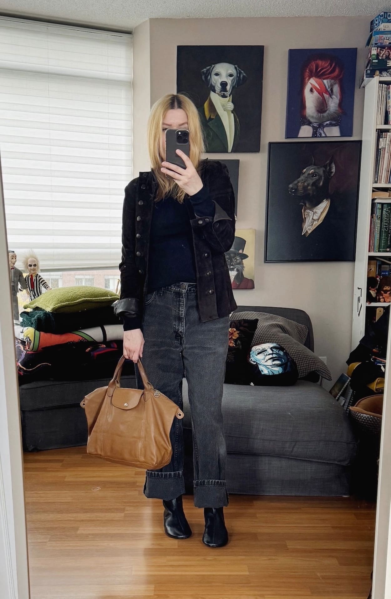Sara of livelovesara is standing in front of a mirror taking a photo of her outfit. She is wearing a black turtleneck with black vintage levis, a brown suede blazer, black boots, and a brown longchamp bag.