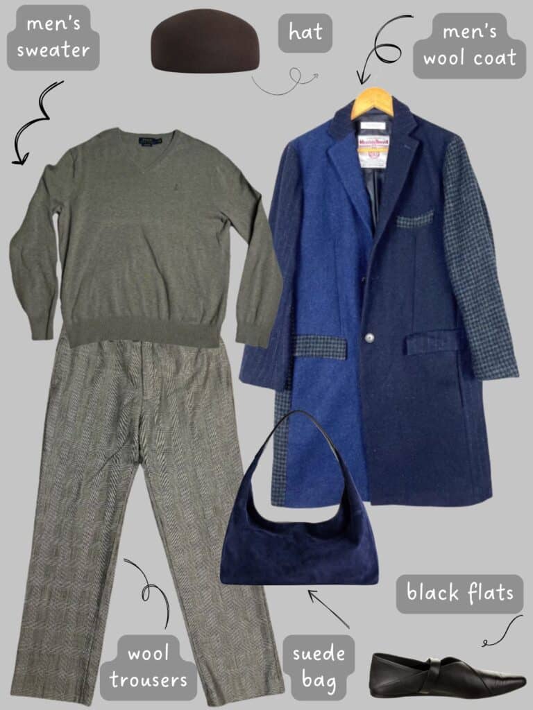 A photo of an outfit of a grey sweater with grey wool trousers, a men's wool coat, a felt hat, black flats, and a blue suede bag.