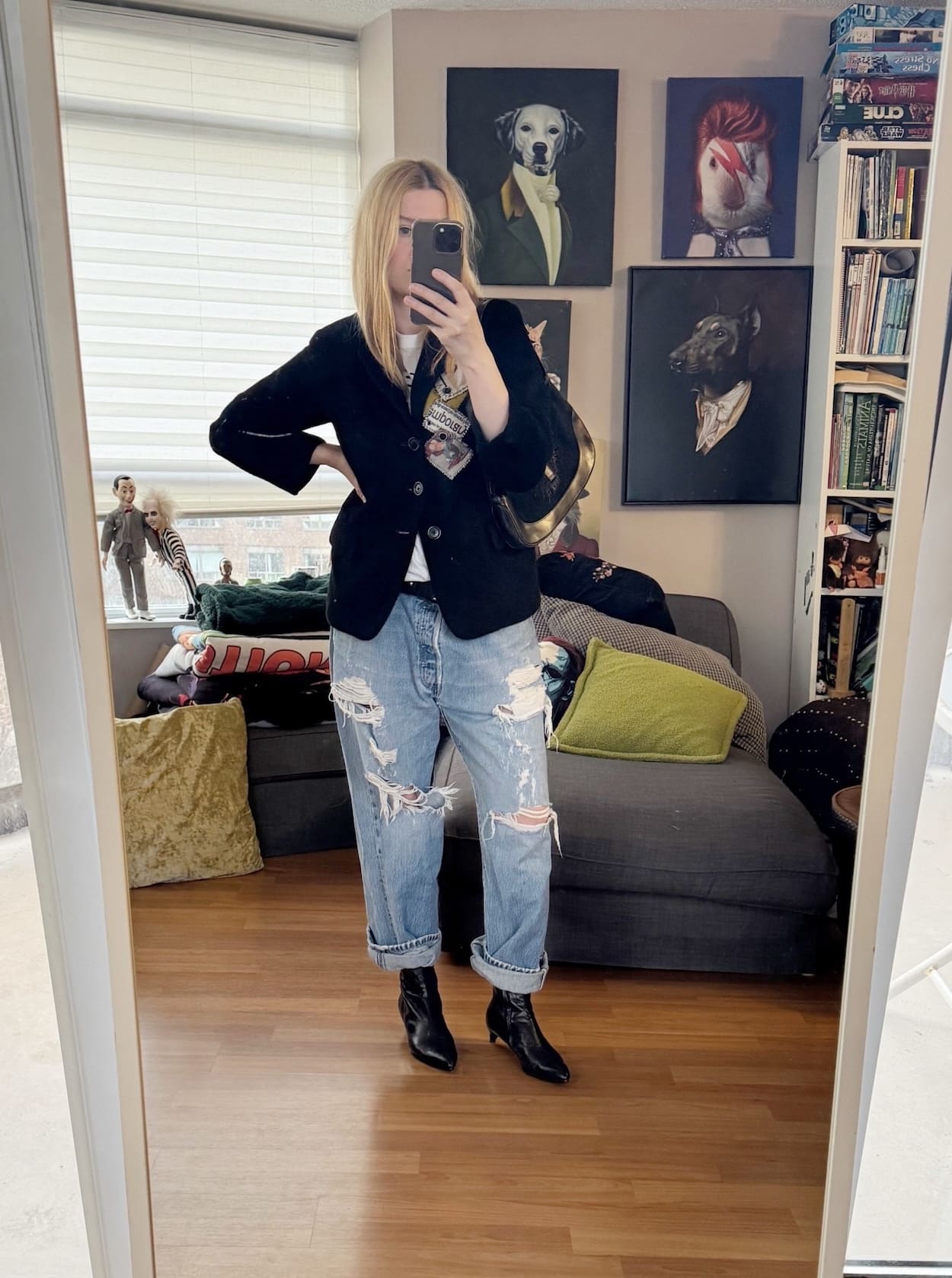 Sara of livelovesara is standing in front of a mirror taking a photo of her outfit. She is wearing a vintage Yohji Yamamoto blazer with a vintage tee, and vintage levis, black boots, and is carrying a vintage Gucci bag.