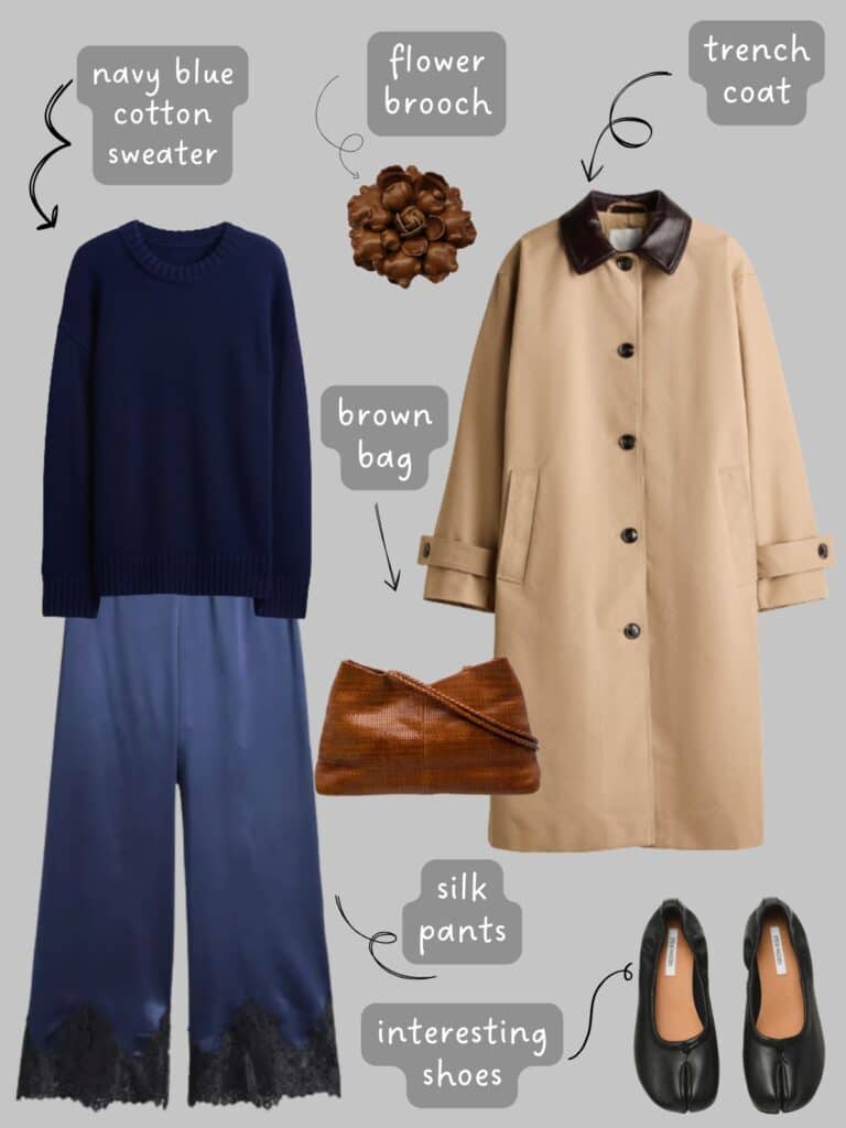 A photo of an outfit of a navy blue sweater with navy blue silk pants, a tan trench coat, flower brooch, brown bag, and black block heels.