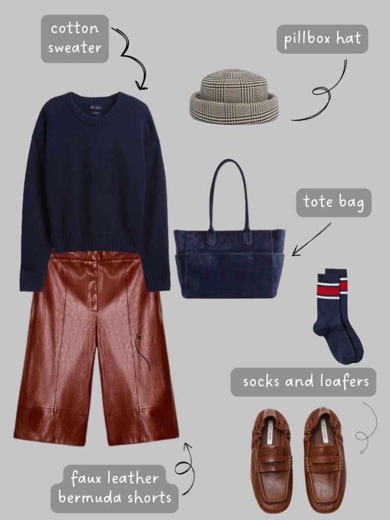 A photo of an outfit of a navy blue cotton sweater with cognac brown faux leather Bermuda shorts, navy blue socks with red striped, brown loafers, a herringbone pillbox har, and a navy blue suede tote.