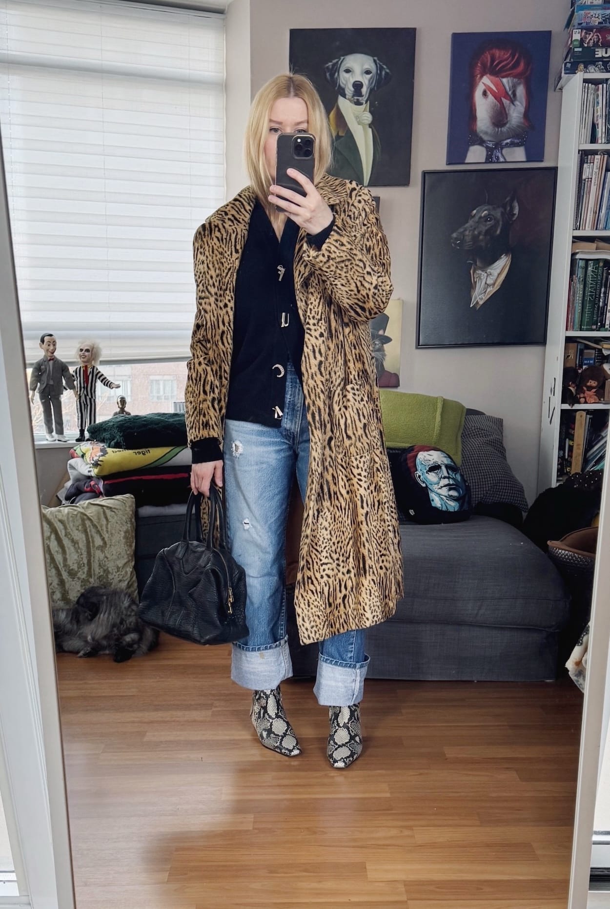 Sara of livelovesara is standing in front of a mirror taking a photo of her outfit. She is wearing a Hades Wool Cardigan with vintage Levis 517s, a vintage animal print coat, snake print boots, and a YSL Easy bag.