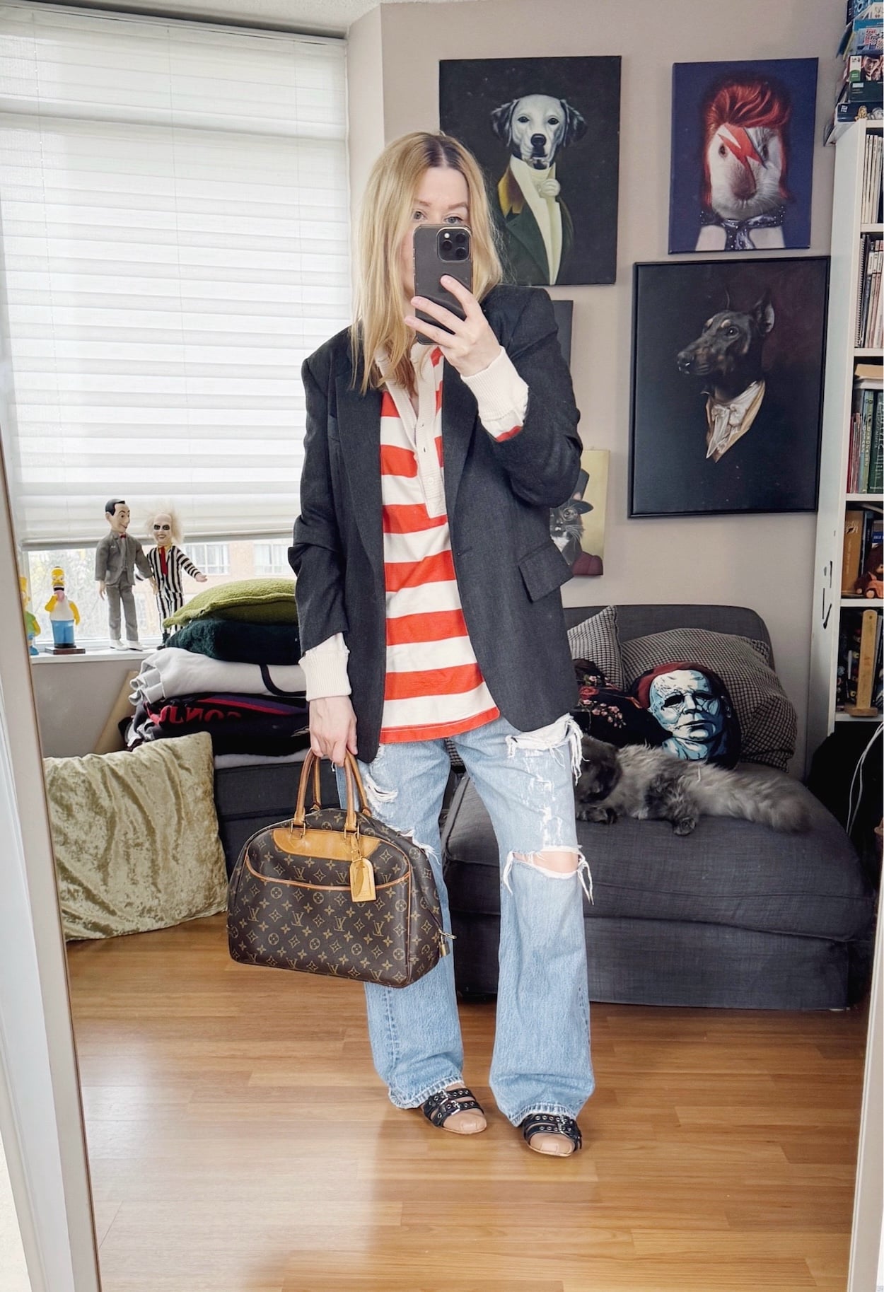 Sara of livelovesara is standing in front of a mirror taking a photo of her outfit. She is wearing an orange an off white striped henley under a grey blazer, distressed vintage Levis, pink Miu Miu flats, and a vintage Louis Vuitton bag.