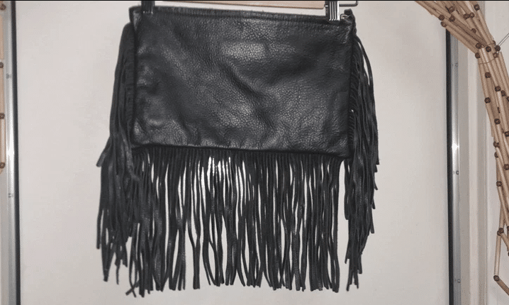 Black leather clutch with long fringe.