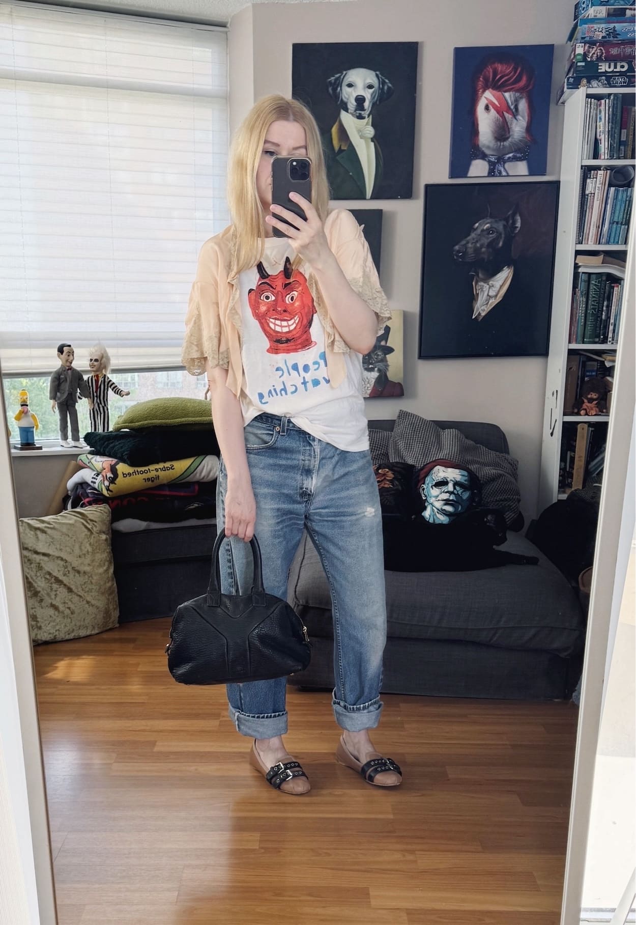 Sara of livelovesara is standing in front of a mirror taking a photo of her outfit. She is wearing an devil People Watching t-shirt with an antique bed jacket, vintage Levi's, Miu Miu flats, and a YSL easy bag.