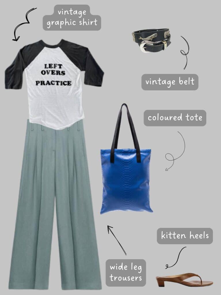A photo of an outfit of a vintage graphic baseball tee, blue-grey wide leg trousers, brown kitten heels, a vintage belt, and a cobalt blue leather tote.
