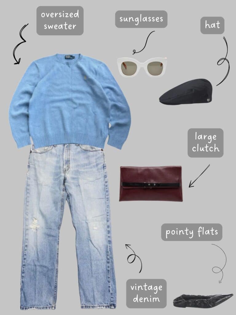 A photo of an outfit of a light blue oversized sweater, blue vintage Levis, a large burgundy clutch, black canvas flat cap, white sunglasses, and black ballet flats.
