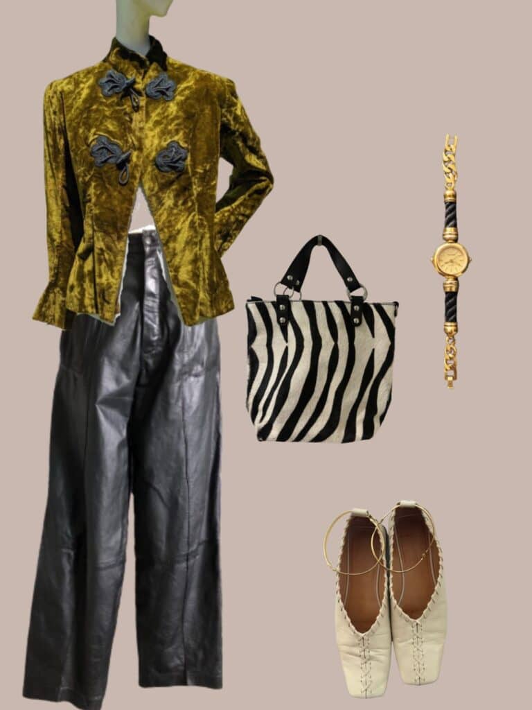 An image of an outfit of a green velvet victorian jacket with frog buttons, pairedwith wide leg black leather pants, a zebra print bag, a gold tone vintage watch, and cream Jil Sander flats.